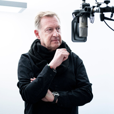 Ein Mann steht vor einem Standmikrofon.