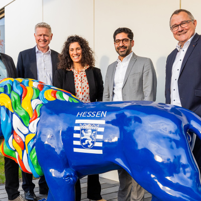 Zu sehen sind 5 Menschen hinter einer blauen Statue des Hessenlöwen. Die Menschen sind von links nach rechts Sascha Gutzeit, Dr. Michael Reckhard, Evren Gezer, Kaweh Mansoori und Dr. Rainer Waldschmidt.