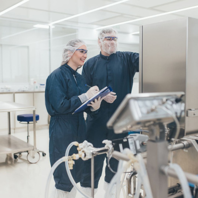 Ein Mann und eine Frau arbeiten in der Reinraumproduktion des Unternehmens BioSpring.