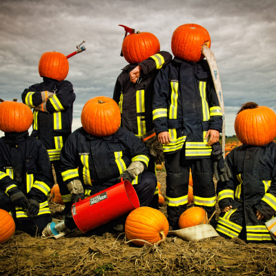 Lustige Feuerwehrmänner mit Kürbis-Köpfen