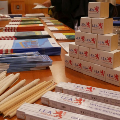 Mehrere Give-aways der LEA Hessen liegen auf einem Tisch.