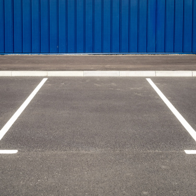 Leere Parkplätze vor einer blauen Wand