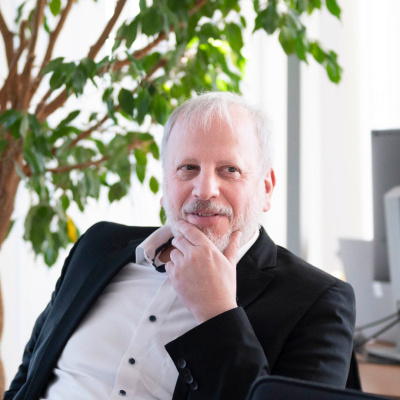 Ein Mann im Anzug sitzt in einem modernen Büro.