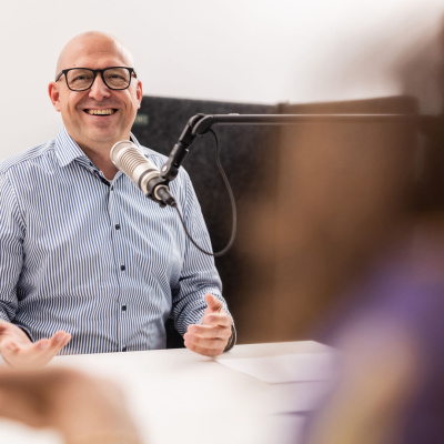 Ein Mann vor einem Mikrofon.