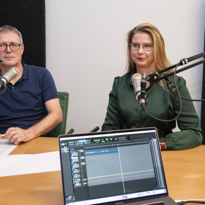Annelie Sanden und Dr. Detlef Terzenbach sitzen vor einem Mikrofon.