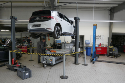 Ein VW-Auto steht auf einer Hebebühne in einer Werkstatt.