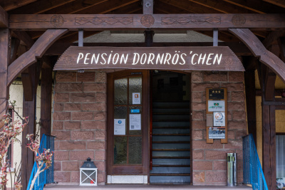 Eingangsbereich des Hotels mit Aufschrift "Pension Dornrös’chen"
