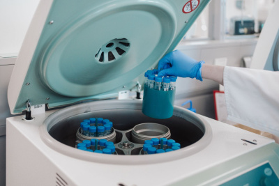 Eine Person hält in einem Labor mehrere Proben in der Hand.