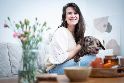 Laura Schleicht sitzt mit ihrem Hund Äppler auf der Couch.
