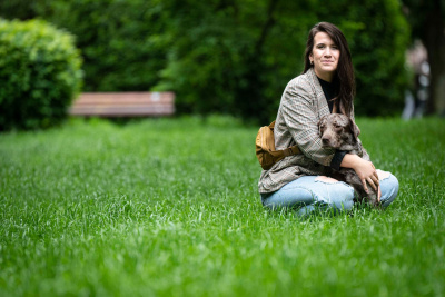 Laura Schleich mit ihrem Hund Äppler auf einer Wiese.