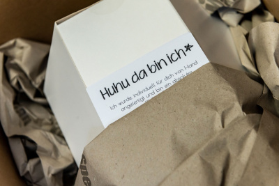 Geschenkkarton mit der Aufschrift: Huhu da bin ich!
