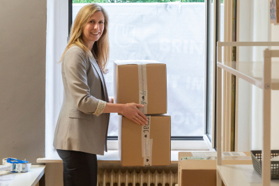 Lena Eckhardt mit zwei Kartons in einem Raum