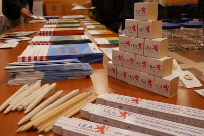 Mehrere Give-aways der LEA Hessen liegen auf einem Tisch.