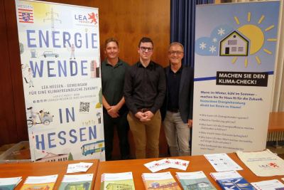 Mehrere Menschen stehen an einem Info-Stand.