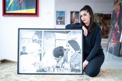 Nadia Doukali mit ihrem Gewinner-Bild, das eingerahmt am Boden steht.