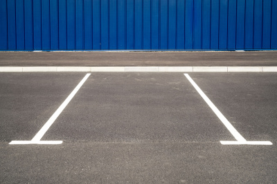 Leere Parkplätze vor einer blauen Wand