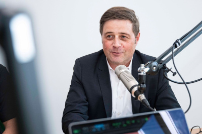 Arne Berg sitzt vor einem Mikrofon.