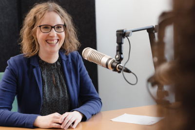 Julia Woth sitzt am Mikrofon für unseren Podcast.