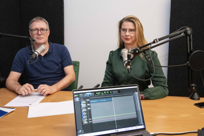 Annelie Sanden und Dr. Detlef Terzenbach sitzen vor einem Mikrofon.