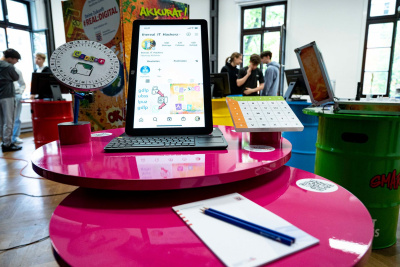 Ein Tablet steht auf einem pinken Tisch.