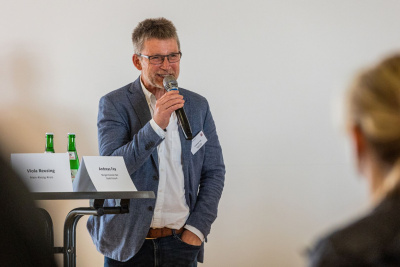 Andreas Fey, Bürgermeister der Stadt Kirtorf, steht mit einem Mikrofon in der Hand auf einer Bühne.