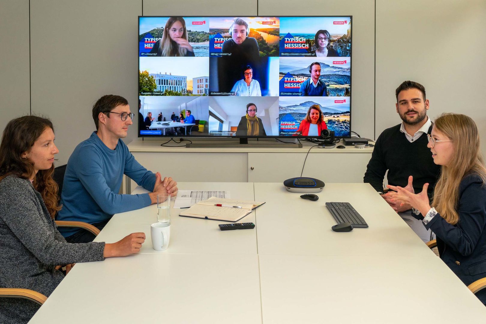 Mitarbeiter im Büro reden mit Kollegen via Videokonferenz
