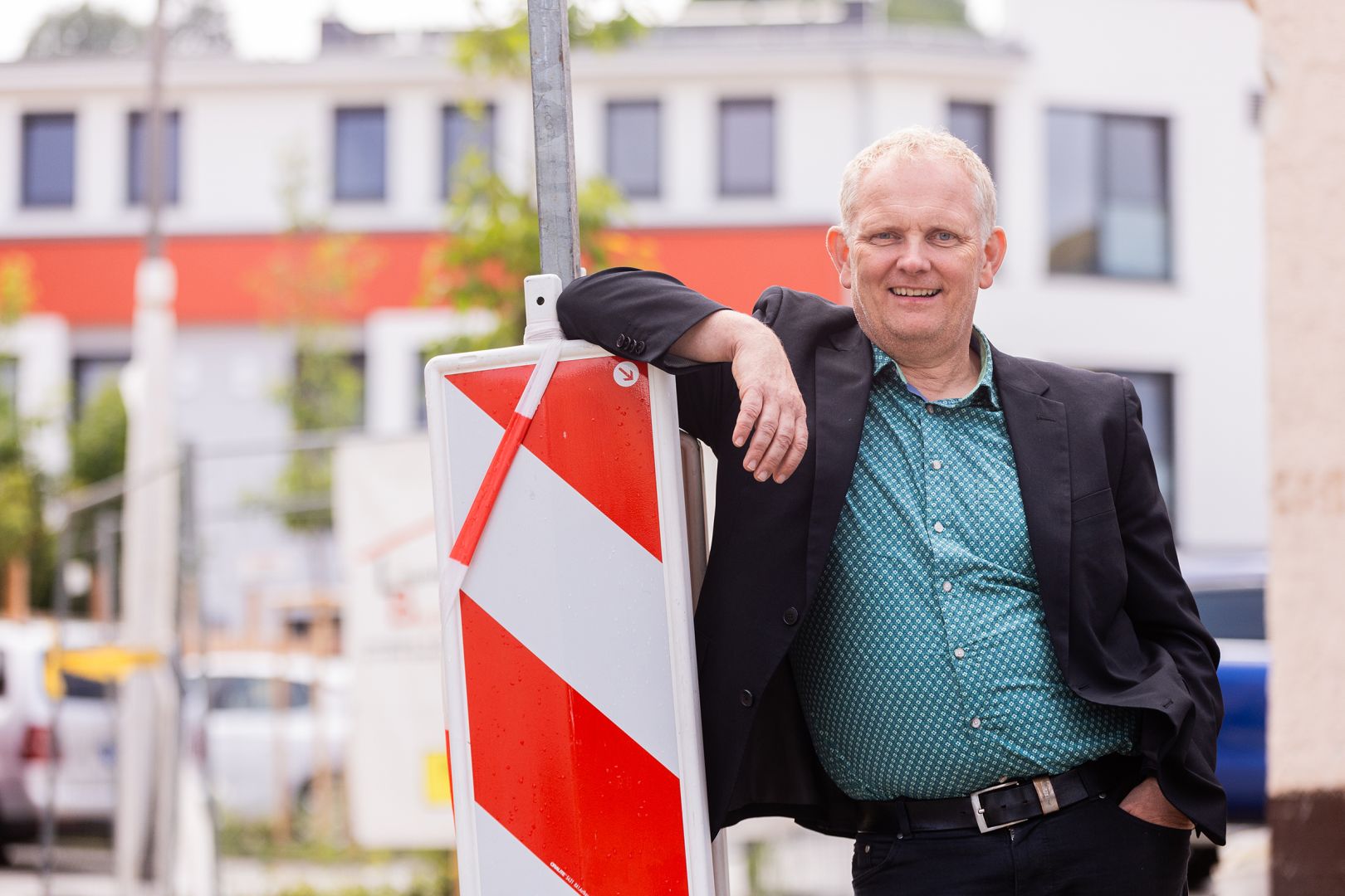 Der ehemalige Bürgermeister der Gemeinde Jossgrund, Rainer Schreiber, lehnt sich an ein Straßenschild.