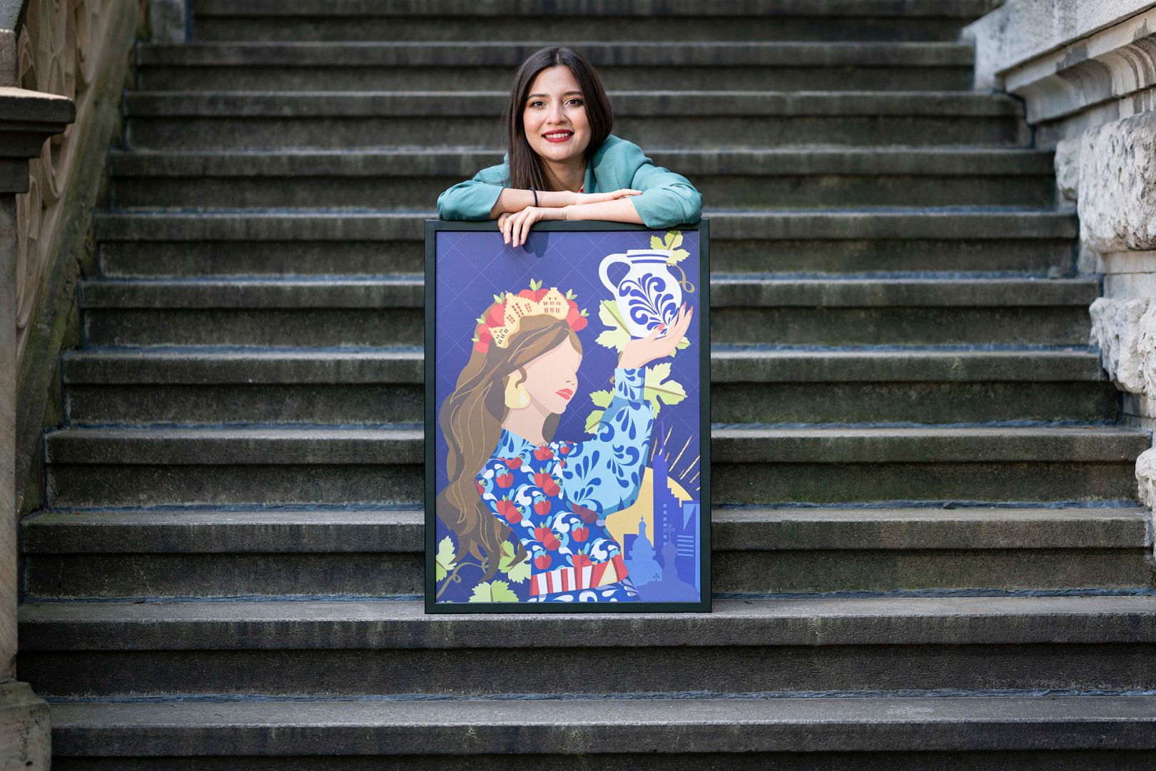 Ana Paola Paniagua sitzt mit ihrem Bild auf einer Steintreppe.